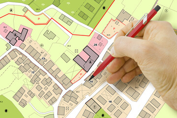 Engineer drawing over an imaginary General Urban Plan of territory with buildings, roads and land...