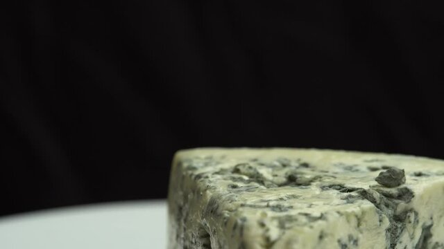 Fragrant blue cheeses with noble mold. Texture of blue cheese. Blue noble blue cheese is spinning on a plate.