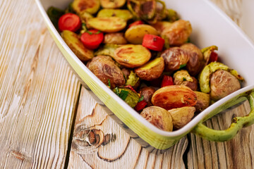 Oven baked vegetables in a baking dish. Vegetable dish close-up. Assorted vegetables roasted with spices, vegan recipe, copy space