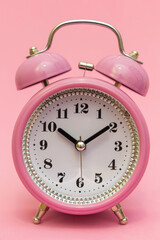 Alarm clock close up. A certain time. An appointment has been made. Time to buy to buy gifts for children for the holidays. Happy time. Signature space, isolated pink background, studio photo.