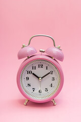 Little pink retro alarm clock on pink isolated background. It's time to change lives, make changes. Use every opportunity. Now is the time to do what you have wanted for a long time.