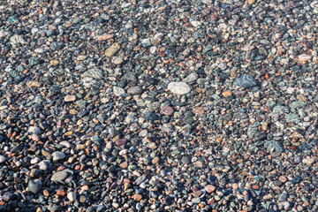 Water texture visible above sea stones. Horizontal image 