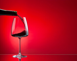 Red wine pouring from bottle into glass