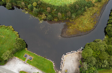 Drone aerial scenery of a river with boat moored on the river side. Keimeens Ireland