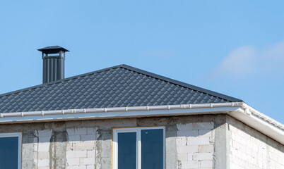 metal pipes on the roof of a small house