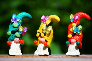 Figurines of fairy-tale dwarfs made of plasticine decorated with butterflies. Christmas decorations.