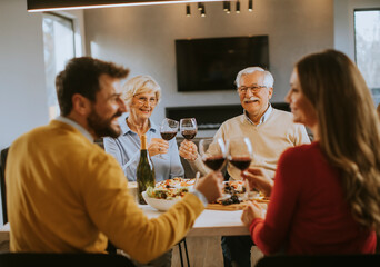 Happy family having dinner with red wine at home