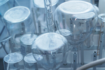 Laboratory glass flasks and test tubes on a rack.