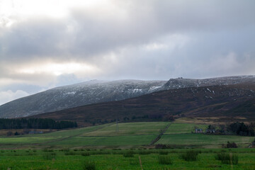 Fototapeta na wymiar DUFFTOWN, MORAY, SCOTLAND - 1 DECEMBER 2021: This is the peak of Moray, Ben Rinnes with some snow coverage and the sun peeking at times in Dufftown, Moray, Scotland on 1 December 2021.