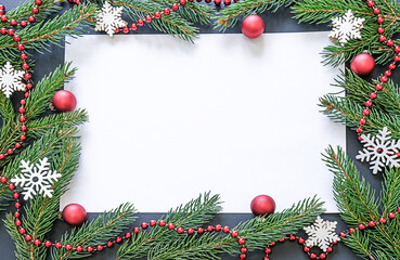 Fototapeta na wymiar A Christmas or New Year's card. Copyspace. A place for your congratulations or advertising. The frame is made of spruce branches, decorated with red balls and snowflakes. High quality photo