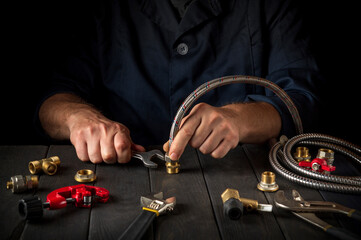 Plumber connects the high pressure hose with a wrench to the brass fittings. Working environment in the workshop during the connection of the gas installation
