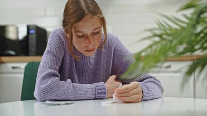 Schoolgirl doing express COVID-19 antigen test at home.