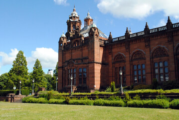Fototapeta premium Red Stone 19th Century Public Building with Cupola & Foreground Gardens & Blue Sky 