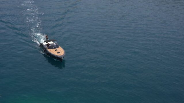 An expensive motor boat sails on the turquoise sea. Top view