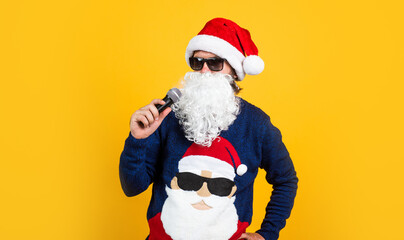 Fototapeta na wymiar bearded santa man singing in microphone in hat smiling while prepare for celebrating happy new year party and christmas holiday in winter going to have xmas gifts, karaoke party