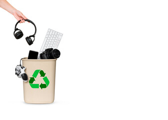 hand throws headphones in a bucket with other gadgets for recycling