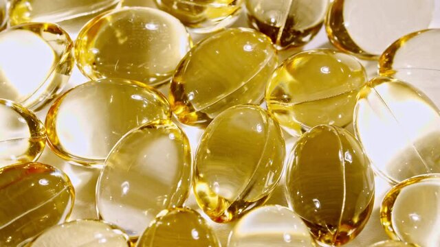 Yellow capsules medical pills rotating closeup. Vitamin C, Omega 3 in oil capsules. Pills and drugs. Pharmaceutical Industry. The medicine concept. Slow motion. High quality 4k footage