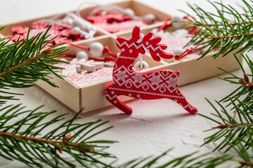 Christmas gift box with wooden deer toys and green fir tree branches. Christmas red wooden deer....