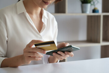 Woman enjoy with online shopping application and typing credit card for fill number to payment.