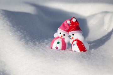 Snowman in winter setting,Christmas background. Two snowmen in red caps.