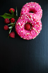 round donuts with pink icing and raspberries. congratulations on mothers day and 8 march 
