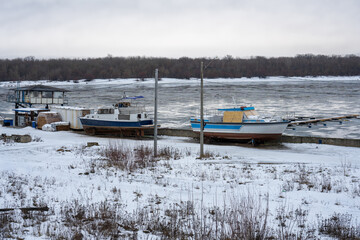 Boats on the snowy shore in winter