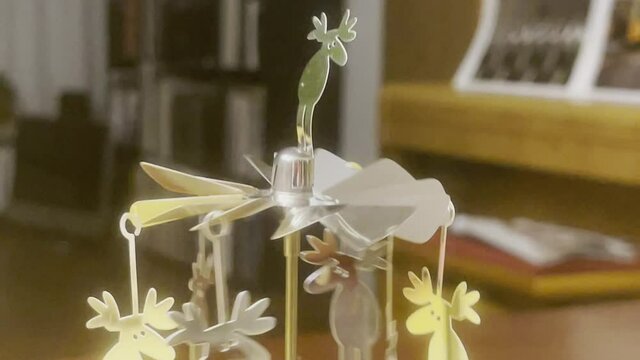Goldene Elche drehen sich &uuml;ber Kerze am Weihnachtskarussell
