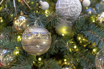 Transparent Christmas ball with stripes and sparkles of gold color.