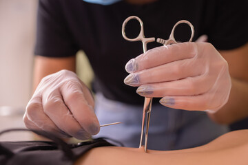 The first piercing. Dressing the earrings on the navel. Female piercing.