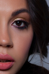 Half close-up of beauty girl with long straight developing hair and radiant eveningtime makeup on her face. Skin care natural cosmetics in the spa salon or cosmetology.