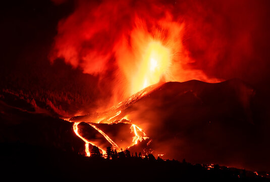 Cumbre Vieja volcano at La Palma erupting at night. Lava streams glows in the dark.