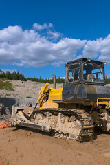 Obraz premium the process of leveling the soil with a modern bulldozer during the construction of a dirt road