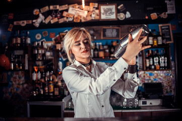 Focused woman bartender intensely finishes his creation in pub