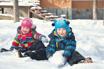 children playing in the yard of his house in the winter outdoors - 472500615