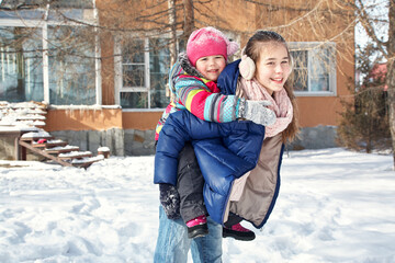 children playing in the yard of his house in the winter outdoors - 472500618