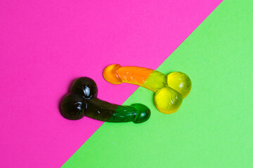 Delicious sweets made from sugar, caramels, interesting shapes on a bright pink and green background