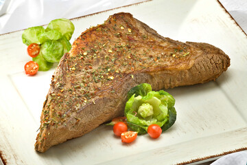 Carne temperada decorada com tomate-cereja e folha de alface