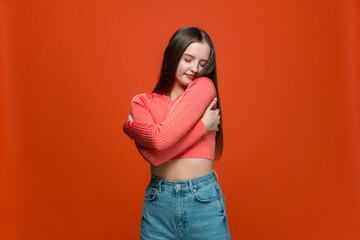 Love yourself. Pretty young teen girl embrace herself with satisfied pleased expression, positive...