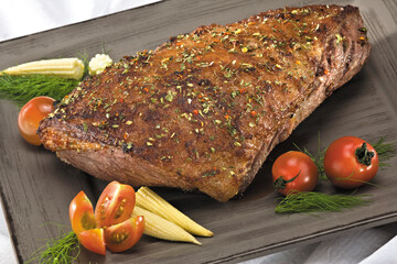 Prato de carne temperada decorada com milho e tomate