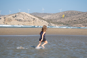 Mädchen rennt durch Wasser am Strand von Rhodos - 472504203