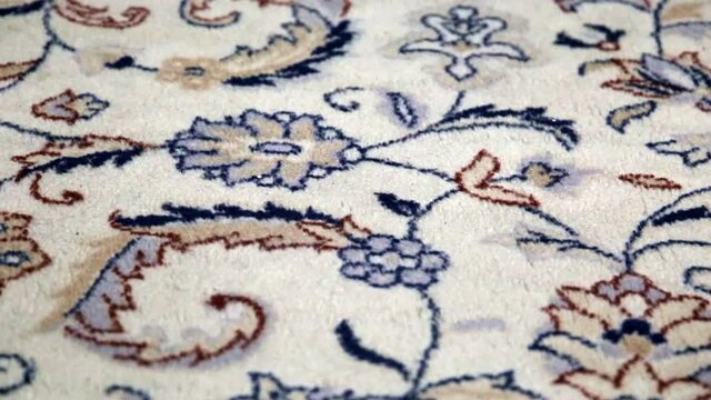 Persian carpet - vintage floral pattern. Close-up of the woolen fabric texture and woven Iranian rug artistic design.