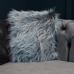 stylish cozy home corner on the sofa with shaggy faux fur cushion