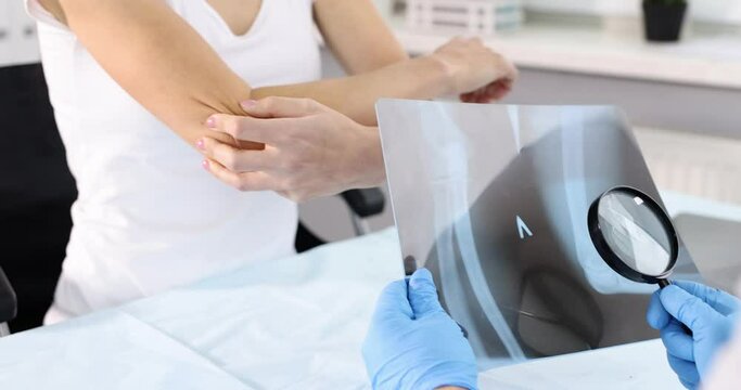 Doctor examines X-ray of elbow pain slow motion 4k movie
