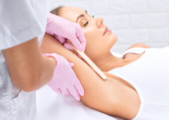 Obraz na płótnie Canvas Elos epilation hair removal procedure on a woman’s body. Beautician doing laser rejuvenation in a beauty salon. Removing unwanted body hair. Hardware ipl cosmetology