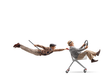 Flying elderly man holding a shopping cart with a man inside