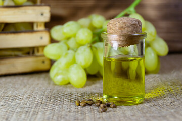 Grape oil seed in small vintage bottle. Heap of grape seeds with green slices and cold press...