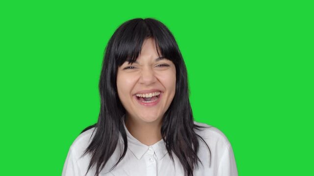 Woman being surprised and laughing. Surprised and smiling face expression of woman looking at camera. Green screen technique.