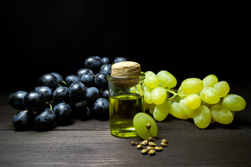 Bottle of natural grape seed oil on dark wooden table. Space for text. Organic cosmetic