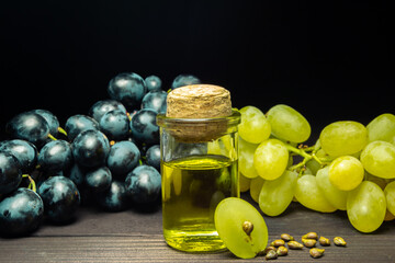 Grape oil seed in small vintage bottle. Heap of grape seeds with green slices and cold press...