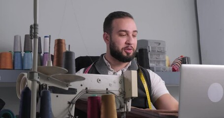 Middle eastern man teaching sewing courses online and talking to students.